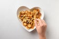 Trendy tiny pancakes for child in plate shape of heart on white. View from above