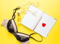 trendy top view of perfume, nail polish, lip stick, lingerie and notepad on yellow background. Beauty product, cosmetic concept. Royalty Free Stock Photo