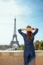 Trendy tourist woman against Eiffel tower in Paris, France