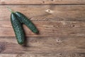 Trendy ugly organic natural cucumber on natural wooden table.