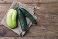 Trendy ugly organic natural cucumber and squash on napkin, on natural wooden background. Copy space