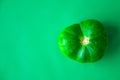 Trendy ugly organic vegetables. Green tomato on green background. Cooking ugly food concept. Top view Royalty Free Stock Photo