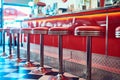 Trendy, vintage and retro interior in a diner, restaurant or cafeteria with funky decor. Booth, old school and chairs by Royalty Free Stock Photo