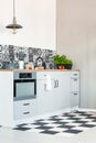 White kitchen interior with elegant wooden cupboards and kitchen accessories