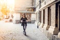 Trendy woman, beautiful brunette girl riding electric scooter in city Royalty Free Stock Photo