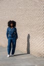 Trendy Woman in Denim Attire Against Brick Wall