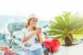 Trendy woman drinking takeaway coffee near her red moped on the Royalty Free Stock Photo