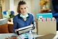 Trendy woman with medical mask organising home office