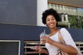 Trendy woman smiling with coffee and cellphone