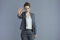 trendy woman worker showing stop gesture isolated on grey