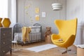 Trendy yellow egg chair in elegant grey nursery Royalty Free Stock Photo