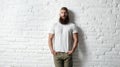 Trendy young bearded man against white brick wall Royalty Free Stock Photo