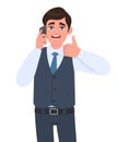 Trendy young business man in waistcoat speaking on phone and showing thumbs up gesture sign. Person calling to mobile, making like Royalty Free Stock Photo