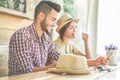 Trendy young couple drinking coffee and using smartphone in cafe bar - Two tourist having fun in summer vacation - Travel and Royalty Free Stock Photo