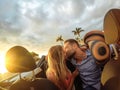 Trendy young couple having a tender moment in convertible car during their road trip