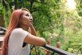 Trendy young diverse Asian girl standing on garden balcony on vacation with wild nature backdrop Royalty Free Stock Photo