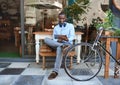 Trendy young man surfing the net at a sidewalk cafe Royalty Free Stock Photo