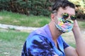 Trendy young man wearing matching cloth mask and Hawaiian shirt