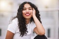 Trendy, young and urban curly hair Mexican girl with attractive lipstick and edgy urban style. Happy, portrait and city Royalty Free Stock Photo