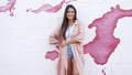 Stylish Woman Standing Against a Pink Paint Splash Wall Royalty Free Stock Photo