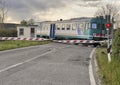 Trenitalia diesel railcar ALn 668 crossing a road in Tuscany, Italy. Royalty Free Stock Photo