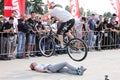 Trial biker jumping over woman