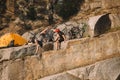 trial bikers resting and giving high five to each other near tent and mountain cycles on rocky