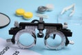 Trial frame with different ophthalmologist tools on light blue background, closeup Royalty Free Stock Photo