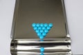 Triangle arrangement blue coated tablet on tray in drugstore business and healthcare concept with copy space