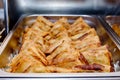 Triangle Crispy Puff pastry in metal tray on buffet line