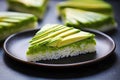 triangle-cut avocado over rice cake on an aluminum plate