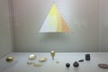 triangle with different colors of golden copper used by ancient colombian tribes and a small pieces used as example