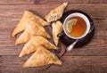 Triangle meat pies with cup of tea .