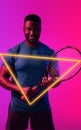 Triangle neon over young african american tennis player with racket over colored background