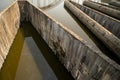 Triangle pattern of concrete structure of an irrigation control system with water and reflection inside.