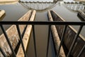 Triangle pattern of concrete structure of an irrigation control system with water and reflection of white concrete railroad bridge