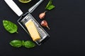 Triangle piece of parmesan cheese on a grater,garlic,green basil. Food ingredients for making pasta, spaghetti, bruschetta, pizza