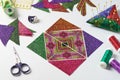 Triangle pieces of fabric laid out in the shape of a patchwork block, sewing and quilting accessories