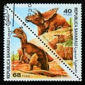 Triangle postage stamp 1997. Dilophosaurus and anchiceratop dinosaur
