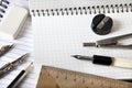 Triangle ruler, compasses, dividers, eraser, a simple pencil and a sharpener lie on a notebook. View from above. Close-up.