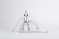 Triangle ruler, protractor and compass on white