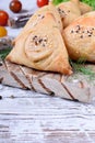 Triangle samsa meat pastry with sesame seeds on wooden board Royalty Free Stock Photo