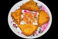 Triangle shape Bread Pakora in a plate on black background with sliced salad Royalty Free Stock Photo