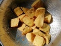 Triangle shape of Fried Tofu in colander for Oil filter. Raw materials of vegetarian food