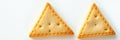 Triangle shaped crackers arranged neatly on a plain surface suggesting a snack or appetizer option for various occasions Royalty Free Stock Photo