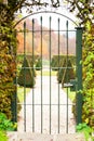 Ancient iron gate with ornamental garden beyond