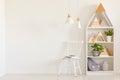 Triangles on shelves in scandi kid`s room interior with white ch