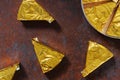 Triangles of unknown processed cheese in gold foil, background