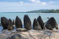 The triangular abstract rocks on white sand beach under fresh blue sky, Khao Saba beach, Phang Nga, Thailand