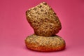 Triangular bread roll stacked on round bun with pink background Royalty Free Stock Photo